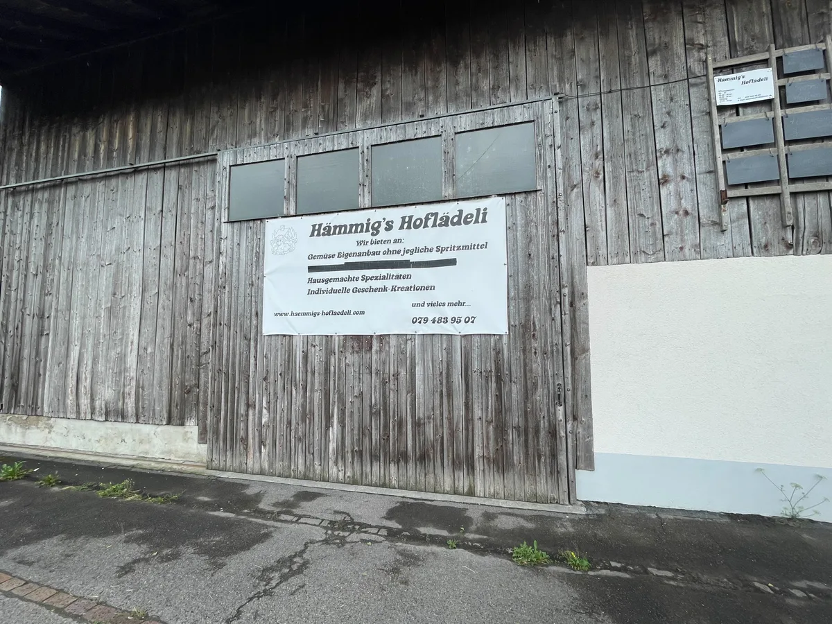 Bild einer Scheune von aussen, auf einem Plakat steht «Hämmig’s Hoflädeli».